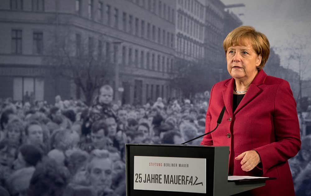 German Chancellor Angela Merkel delivers a speech in front of a historical photograph in the Berlin Wall memorial at Bernauer Strasse in Berlin, Germany.