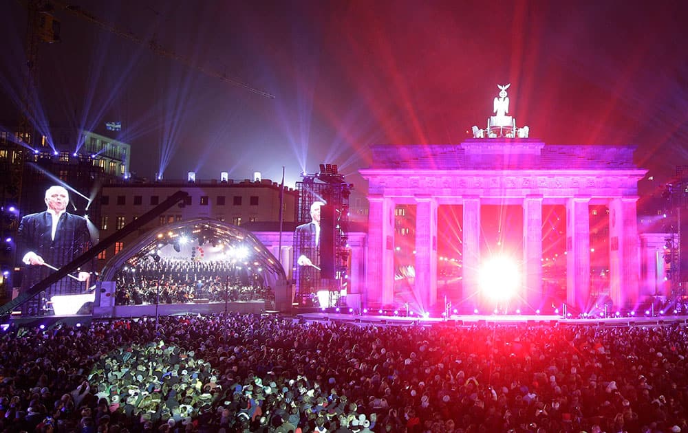 Daniel Barenboim conducts the Berlin Philharmonic Orchestra in front of Brandenburg Gate during the central event commemorating the fall of the wall in Berlin, Germany.