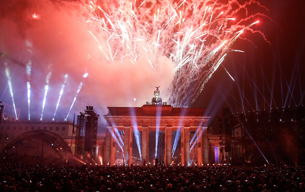 Fireworks explode behind Brandenburg Gate during the central event commemorating the fall of the wall in Berlin, Germany.