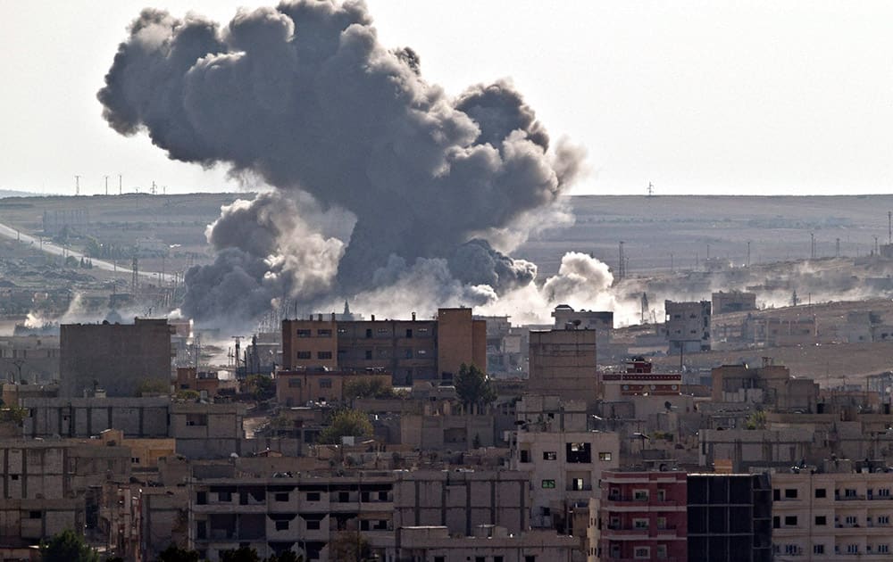 Smoke rises over the Syrian city of Kobani, following a US led coalition airstrike, seen from outside Suruc, on the Turkey-Syria border.