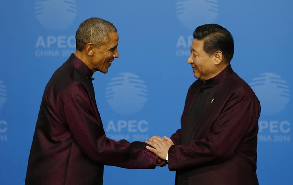 US President Barack Obama, left, is greeted by Chinese President Xi Jinping for the dinner hosted by Xi for APEC leaders at the Beijing National Aquatics Center in Beijing.
