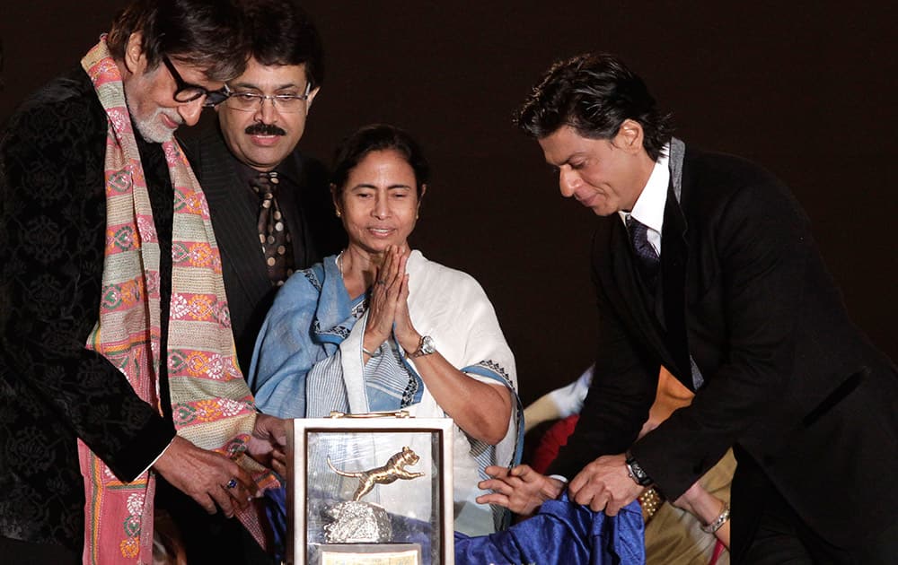 Bollywood actors Amitabh Bachchan, left and Shahrukh Khan, right, unveil the trophy for the top award as as West Bengal state Chief Minister Mamata Banerjee, applauds during the inauguration of the Kolkata International Film Festival.
