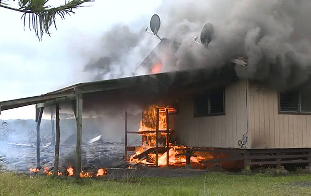 In this image made from video provided by the County of Hawaii, lava flow from the Kilauea Volcano burns a residential structure.