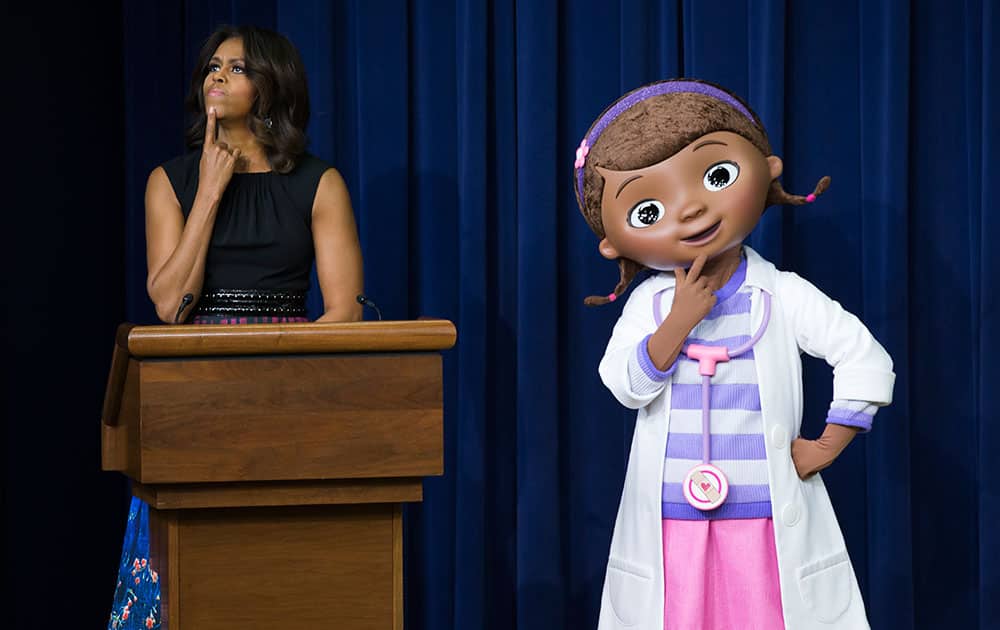 First lady Michelle Obama, left, pauses as she delivers remarks during an event with military children and families that screened a special Veteran's Day episode of Disney's `Doc McStuffins,` that explores the emotions children face when a parent is deployed, at the White House complex, in Washington.