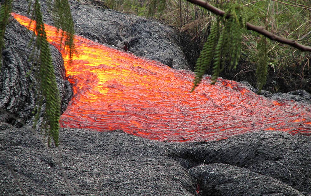 This photo provided by the US Geological Survey shows the lava flow from the Kilauea Volcano that began on June 27 as it pours from an active breakout near the Pahoa transfer station on the Big Island of Hawaii. A small flow of lava moved closer to a now-closed refuse transfer station on Hawaii's Big Island, but the main area of the molten rock hasn't crept any closer to the small town of Pahoa, the US Geological Survey said.