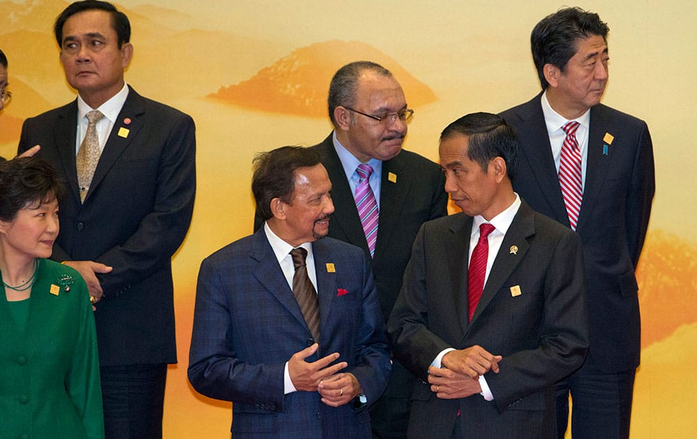 Brunei's Sultan Hassanal Bolkiah, third left, chats with Indonesia's President Joko Widodo, second right, before a group photo at the Asia-Pacific Economic Cooperation (APEC) summit at the International Convention Center in Yanqi Lake, Beijing.