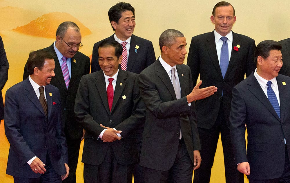 US President Barack Obama, fifth left, gestures near Chinese President Xi Jinping, right, as Brunei's Sultan Hassanal Bolkiah, right, and Indonesia's President Joko Widodo, third left, laugh after a group photo at the Asia-Pacific Economic Cooperation (APEC) summit at the International Convention Center in Yanqi Lake, Beijing.