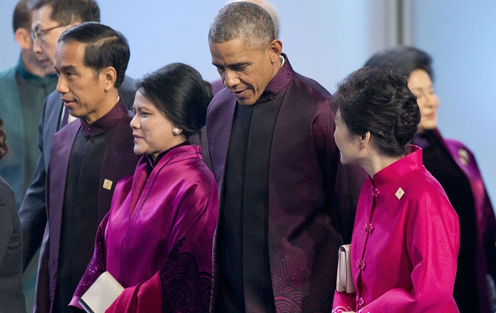 President Barack Obama, center, walks out with South Korean President Park Geun-hye, right, Indonesian President Joko Widodo, far left, popularly known as `Jokowi`, and his wife Iriana, second from the left, following the Asia-Pacific Economic Cooperation (APEC) Summit family photo, in Beijing. 