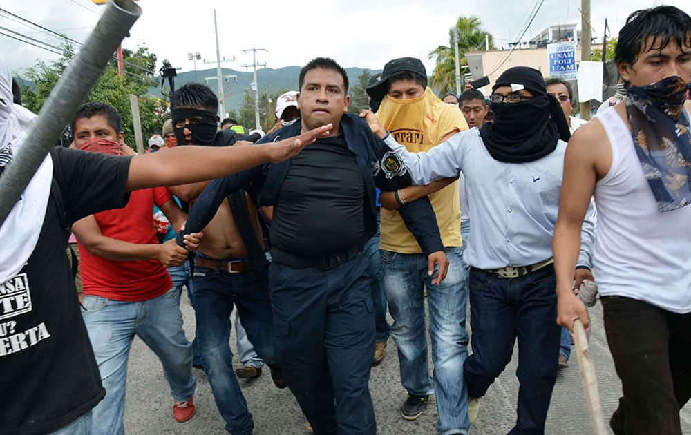 Teachers detain a police during a clash with riot police in Chilpancingo, Mexico.