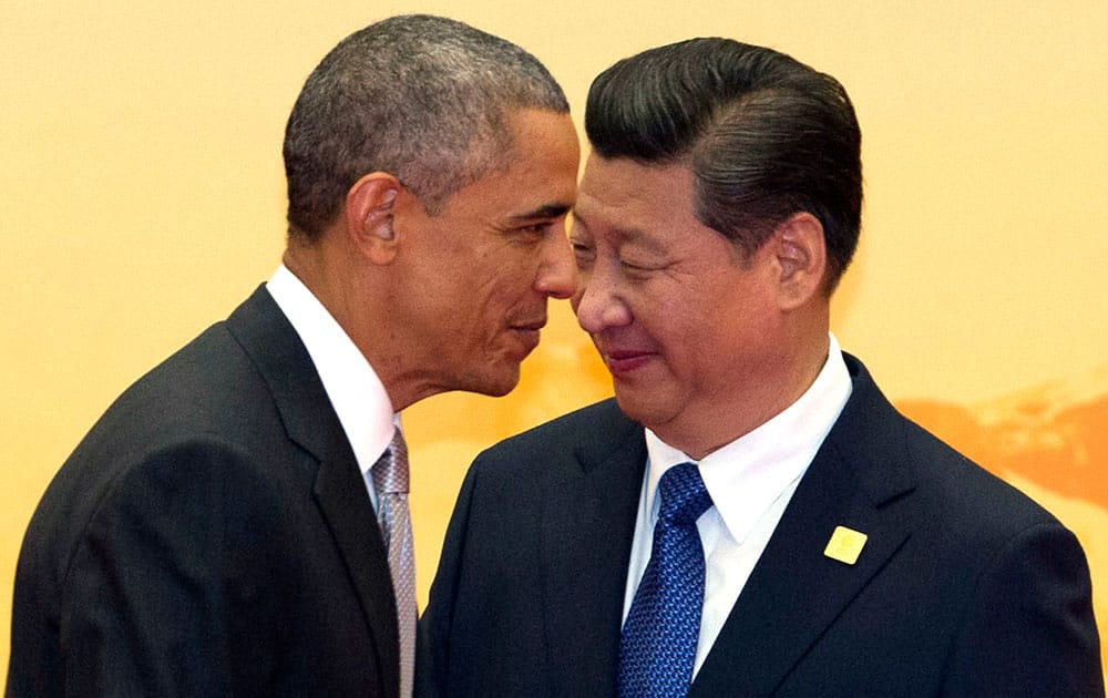 US President Barack Obama, left, walks past Chinese President Xi Jinping during a welcome ceremony for the Asia-Pacific Economic Cooperation (APEC) summit at the International Convention Center in Yanqi Lake, Beijing.