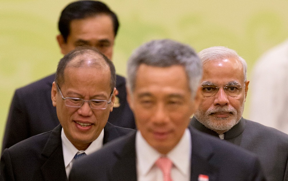 Prime Minister Narendra Modi, Philippine President Benigno Aquino III, and Singaporean Prime Minister Lee Hsien Loong, walk back to their seats after posing for a group photo during the 12th ASEAN-India summit at the Myanmar International Convention Center in Naypyitaw, Myanmar.