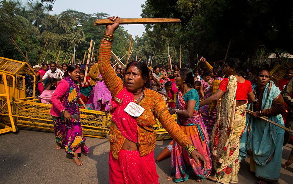 Women employed on temporary basis nationwide to cook midday meals for students at government run schools break a police barricade as they protest to seek permanent employment benefits and better wages in New Delhi.