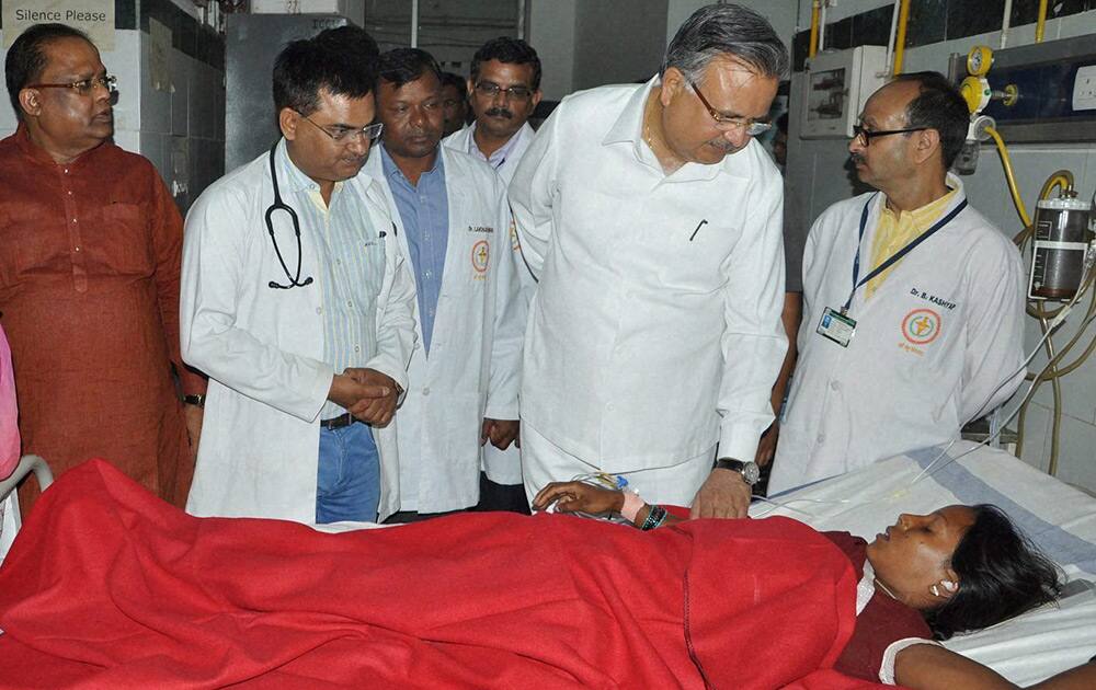 Chhattisgarh Chief Minister Raman Singh meets a woman who underwent sterilization surgeries receive treatment at the CIMS hospital in Bilaspur, Chhattisgarh.