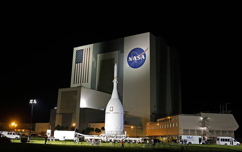The Orion Spacecraft moves by the Vehicle Assembly Building on its approximately 22 mile journey from the Launch Abort System Facility at the Kennedy Space Center to Space Launch Complex 37B at the Cape Canaveral Air Force Station,  in Cape Canaveral, Fla. The test flight for Orion is scheduled to launch on Dec. 4.