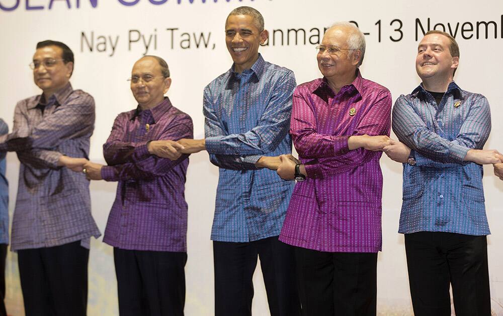 US President Barack Obama, center, holds hands with other leaders during a group photo before a gala dinner at the Myanmar International Convention Center in Naypyitaw, Myanmar. From left are Chinese Prime Minister Li Keqiang, Myanmar President Thein Sein, Obama, Malaysian Prime Minister Najib Razak and Russia Prime Minister Dmitry Medvedev. 