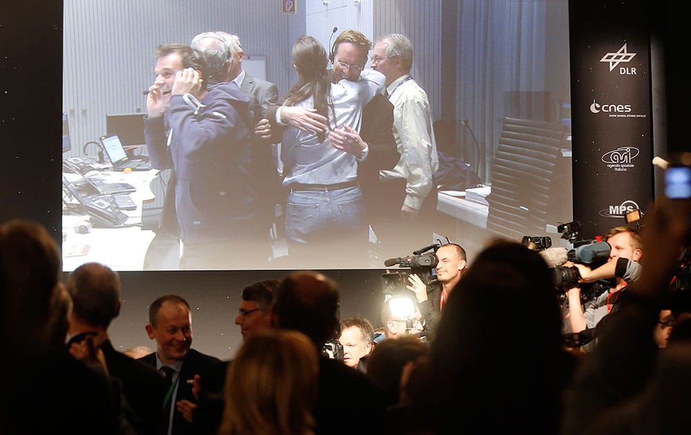 Celebrating scientists in the main control room appear on a video screen at the European Space Agency after the first unmanned spacecraft Philae landed on a comet called 67P/Churyumov-Gerasimenko, in Darmstadt, Germany.