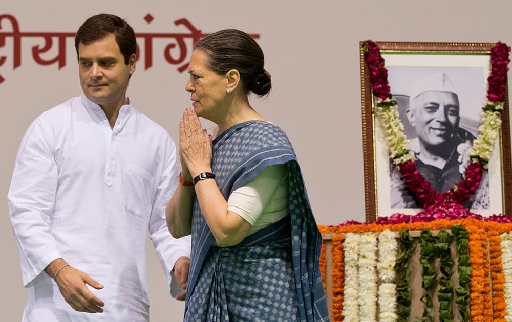 Congress party President Sonia Gandhi, right, and her son and Vice President Rahul Gandhi arrive for celebrations marking the 125th birth anniversary of the first Indian Prime Minister Jawaharlal Nehru, portrait seen, in New Delhi.