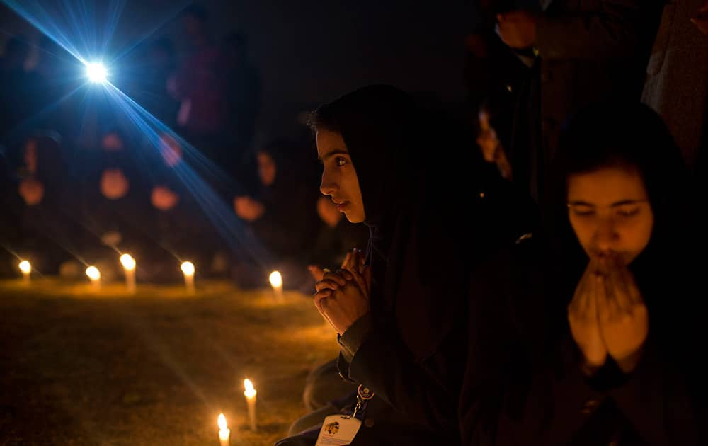 Kashmiri schoolgirls pray during a candle light vigil for flood victims in Srinagar.