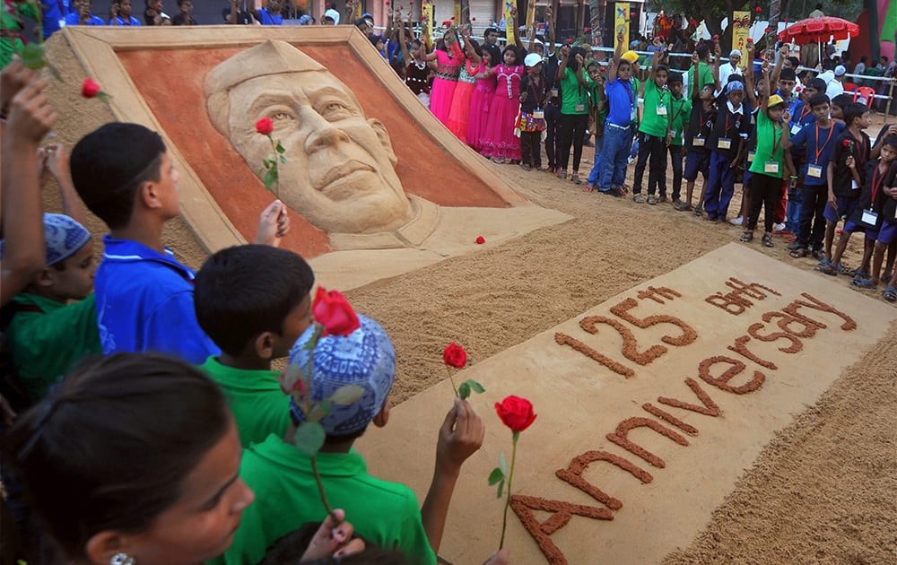 Students pay tribute to a sand sculpture of Pandit Jawaharlal Nehru made by noted sand artist Sudarshan Pattanaik on the eve of his 125th Birth anniversary in Bhubaneswar.