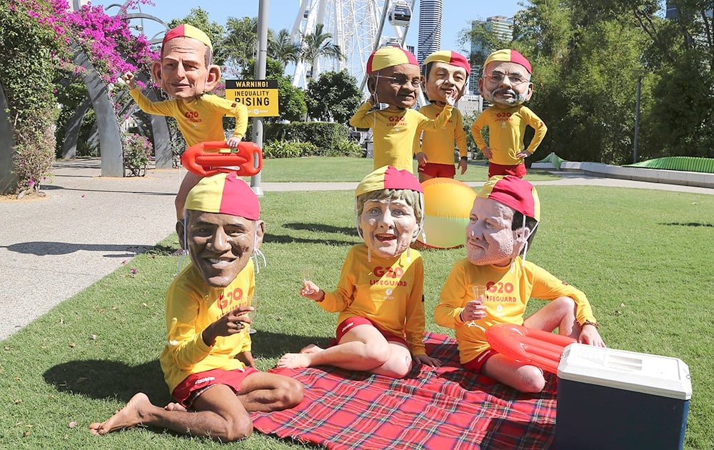 Demonstrators wearing large caricature heads of world leaders, Australian Prime Minister Tony Abbott, South African President Jacob Zuma, Chinese President Xi Jinping, Indian Prime Minister Narendra Modi, US President Barack Obama, German Chancellor Angela Merkel and British Prime Minister David Cameron pose for a photo dressed as life guards ahead of the G-20 summit in Brisbane, Australia.