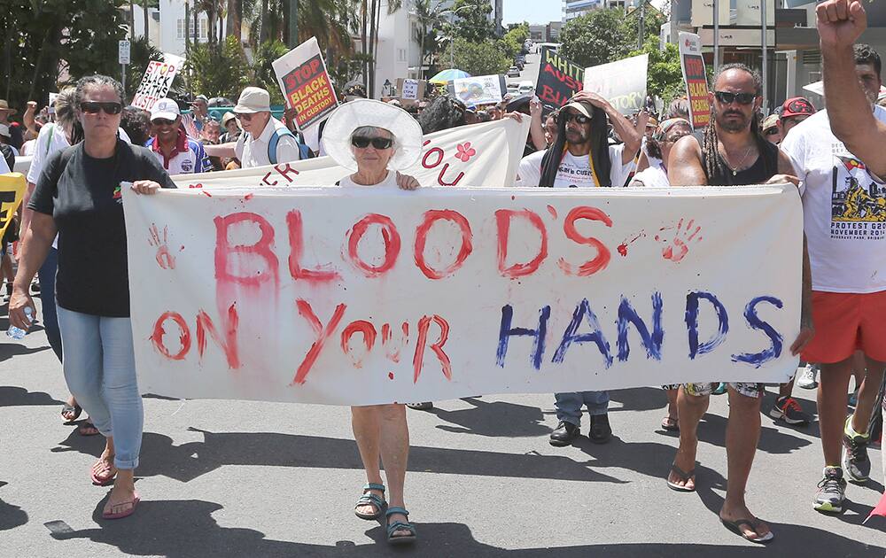 Protesters hold signs and chant as they march through the streets near the Brisbane Convention Center during a demonstration highlighting the fight for justice for Aboriginal deaths in custody ahead of the G-20 summit in Brisbane.