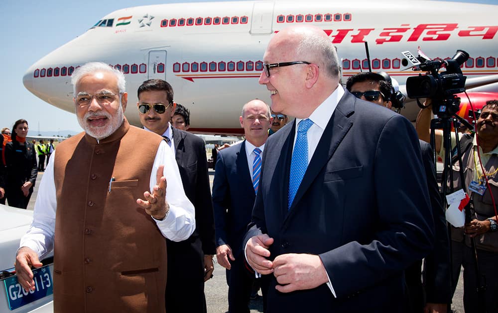 PM Narendra Modi walks with Australia's Attorney-General George Brandis on his arrival at Brisbane Airport ahead of the G-20 summit in Brisbane, Australia.