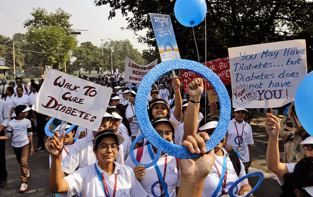 School students carry blue ring, the symbol of diabetes, and placards as they participate in a rally on World Diabetes Day in Kolkata.