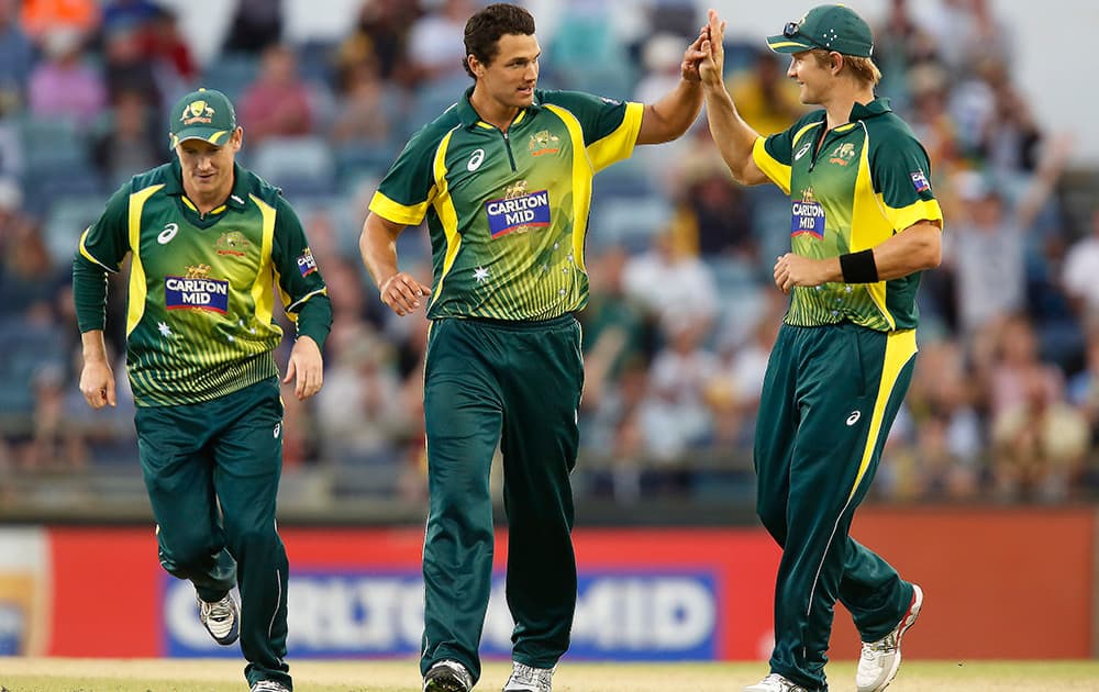 Australia's Nathan Coulter-Nile, is congratulated by teammate Shane Watson, after taking a wicket during their one day international cricket match against South Africa in Perth, Australia.