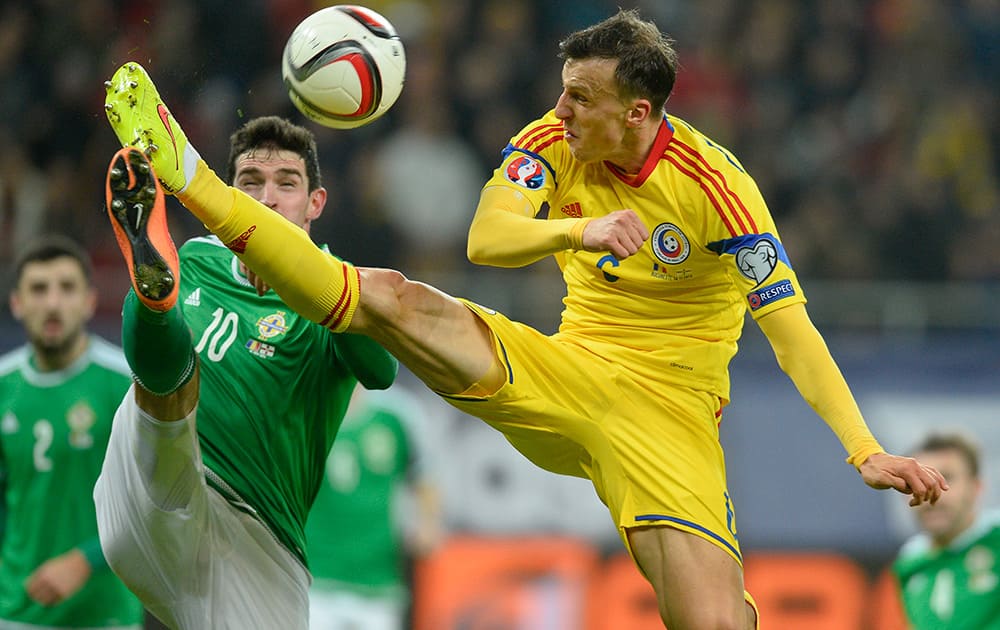 Romania's Vlad Chiriches and Northern Ireland's Kyle Lafferty, challenge for the ball during a Group F, Euro 2016 qualifying soccer match between Romania and Northern Ireland, at the National Arena stadium in Bucharest, Romania.