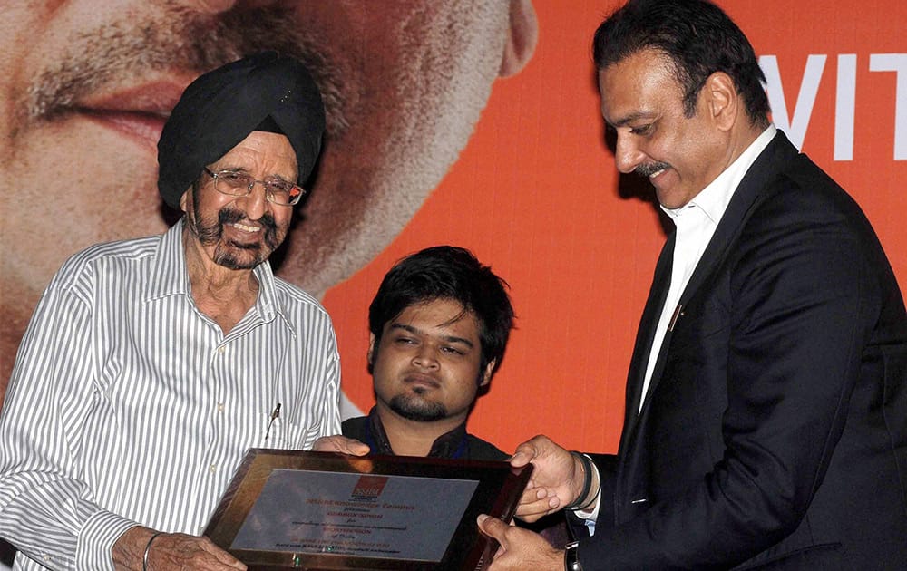 Team Indias director for cricket Ravi Shastri felicitates former Indian hockey player and Olympian gold medalist Gurbax Singh (L) during a felicitation function in Kolkata.
