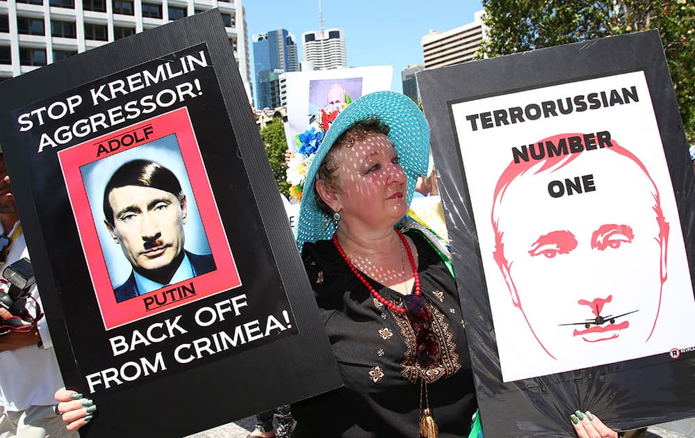 An anti-Russian protester holds placards at a rally during the G-20 in Brisbane, Australia. The protesters staged the rally against the downing of Malaysia Airlines Flight MH17 over eastern Ukraine on July 17 this year. 