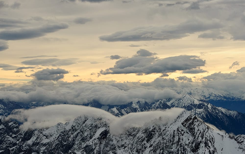 Clouds partly cover the sky above Wetterstein mountains near Garmisch-Partenkirchen, in the German Alps at sunrise. 