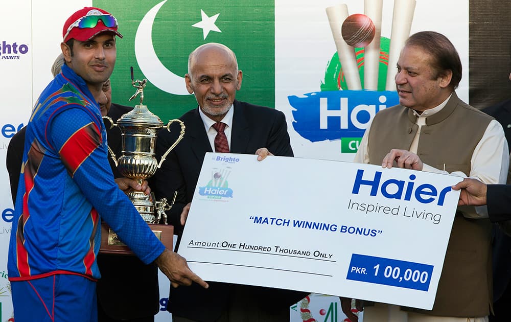 Afghan President Ashraf Ghani and Pakistani Prime Minister Nawaz Sharif, present a trophy and a large symbolic monetary certificate to Mohammad Nabi, left, captain of the winning Afghan cricket team following a friendly cricket match between Pakistan and Afghanistan's junior teams, in Islamabad, Pakistan.