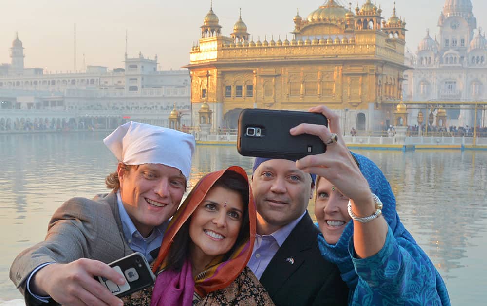 Governor of South Carolina Nikki Haley, second left, poses for a selfie with her husband Michael Haley, second right, and others in front of the Golden Temple, Sikh's holiest shrine, in Amritsar, India.