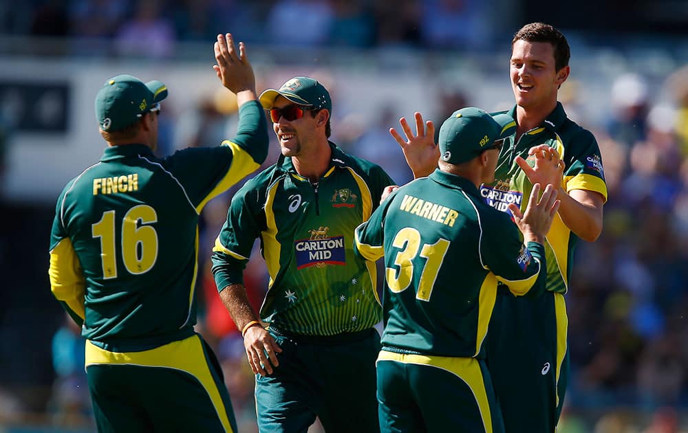 Australia's Josh Hazlewood, right, is congratulated by team mates after taking the wicket of South Africa's Quinton de Kock during their second one-day international cricket match in Perth, Australia.