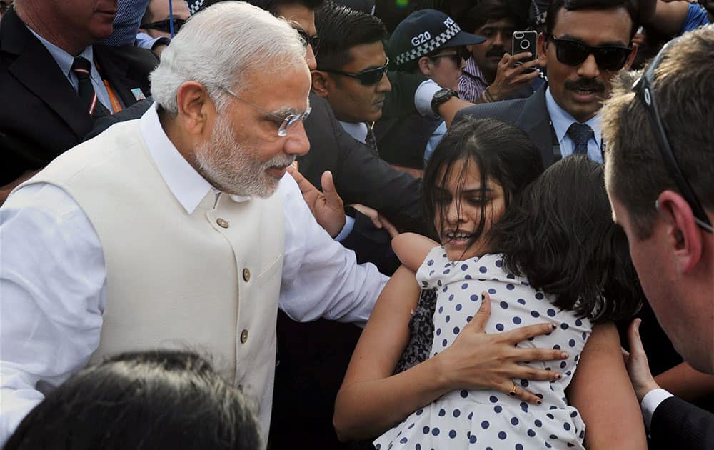 Prime Minister Narendra Modi with one of the supporters as he arrives to unveil the statue of Mahatma Gandhi at Roma Street in Brisbane, Australia.