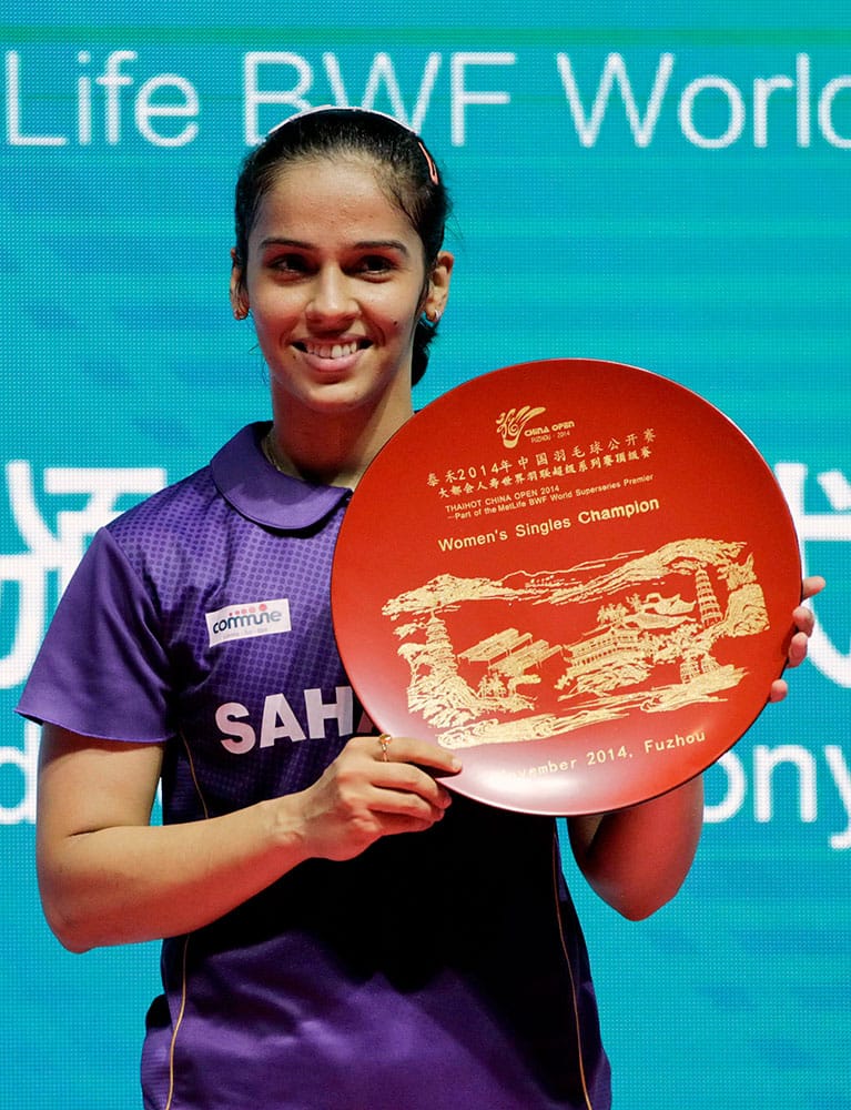 India's Saina Nehwal poses with the trophy on podium after she won the women's singles final against Japan's Akane Yamaguchi in China Open Badminton in Fuzhou.
