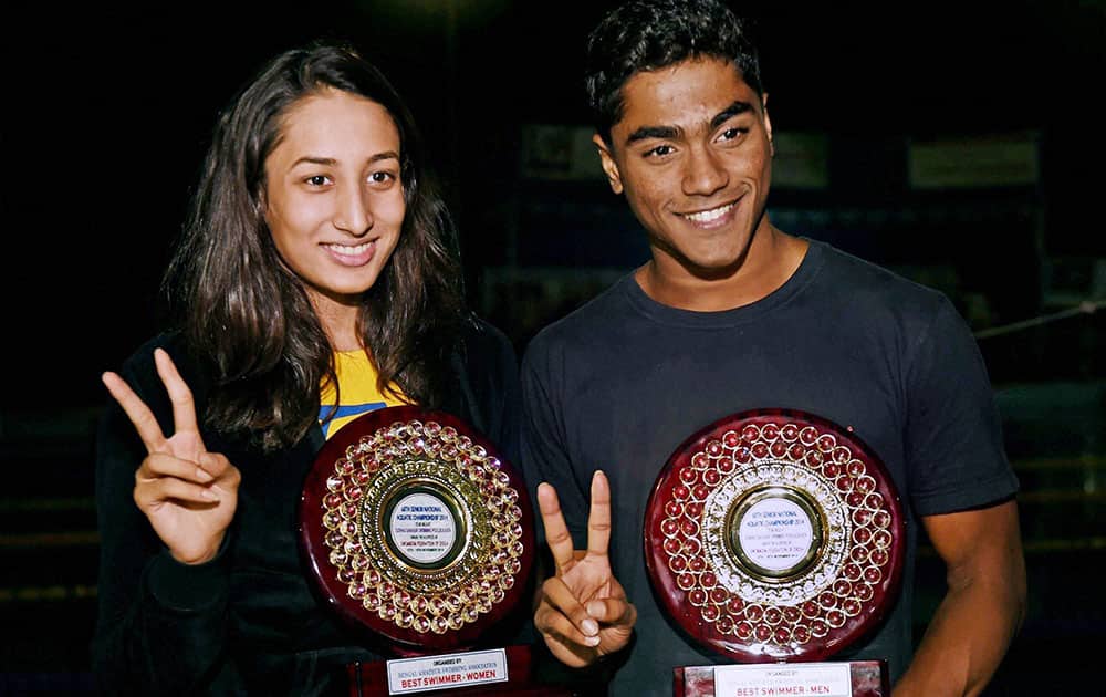 Mens Best Swimmer P.S. Madhu of SSCB and womens best swimmer Maana Patel of Gujarat pose with their trophies on the last day of 68th Senior National Aquatic Championship-2014.