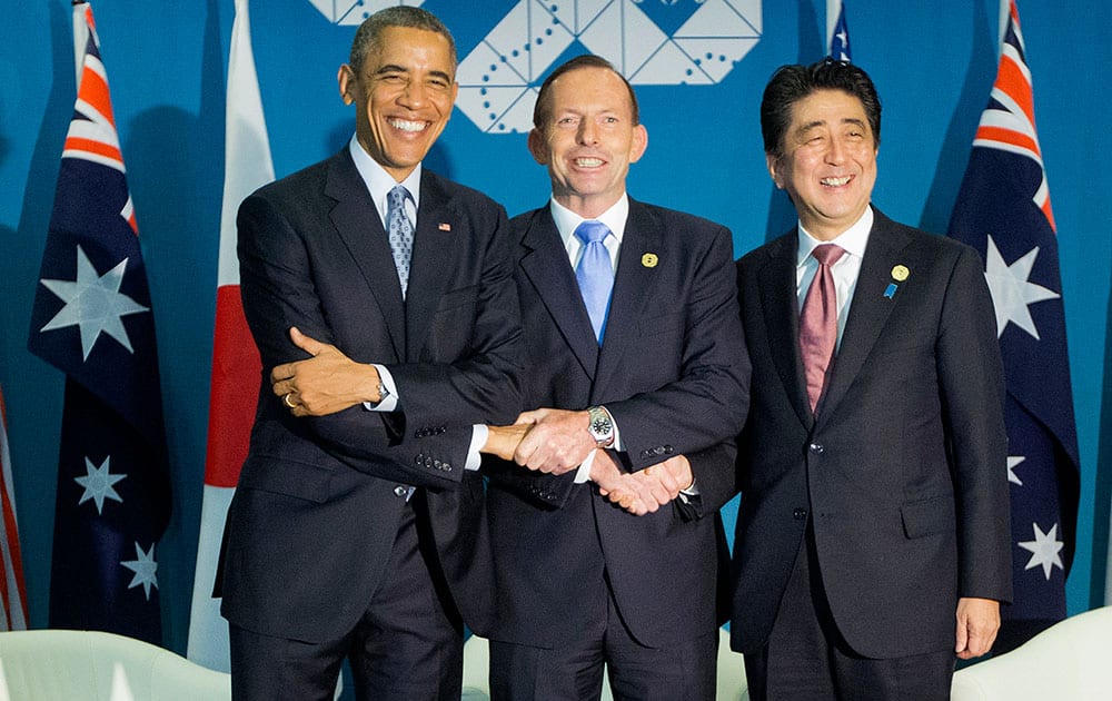 US President Barack Obama, left, Australian Prime Minister Tony Abbott, center, and Japanese Prime Minister Shinzo Abe, right, shake hands at the start of their meeting at the G20 Summit in Brisbane, Australia.