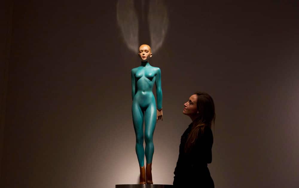 An employee of the Christie's auction house poses for photographs beside the Allen Jones sculpture 
