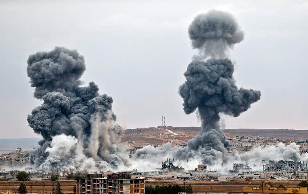 Smoke rises from the Syrian city of Kobani, following airstrikes by the US led coalition, seen from a hilltop outside Suruc, on the Turkey-Syria border.