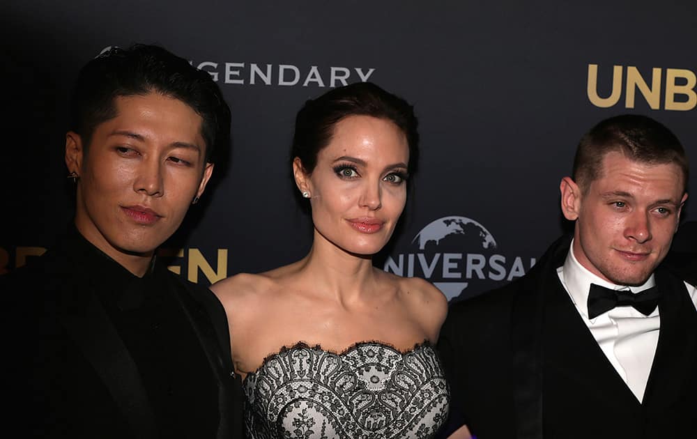 Movie star Angelina Jolie, director of 'Unbroken', poses for photos with actors Miyavi of Japan and Jack O'Connell of Britain at the World Premiere of their film in Sydney.