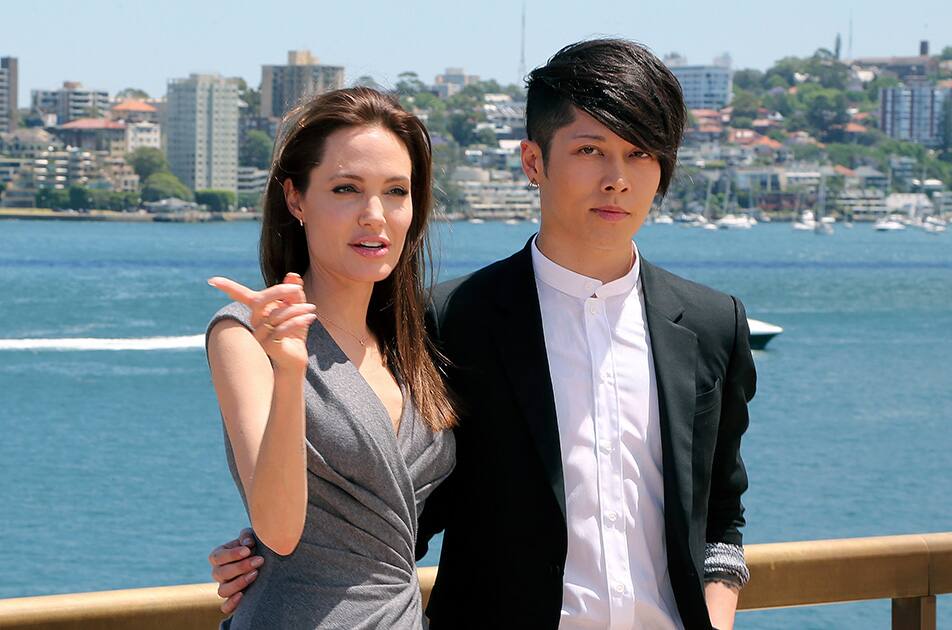 Angelina Jolie, who directed and produced the film 'Unbroken,' poses for a photo with Japanese musician Miyavi who made a debut as an actor in her film, after a press conference following the movie’s world premiere in Sydney.