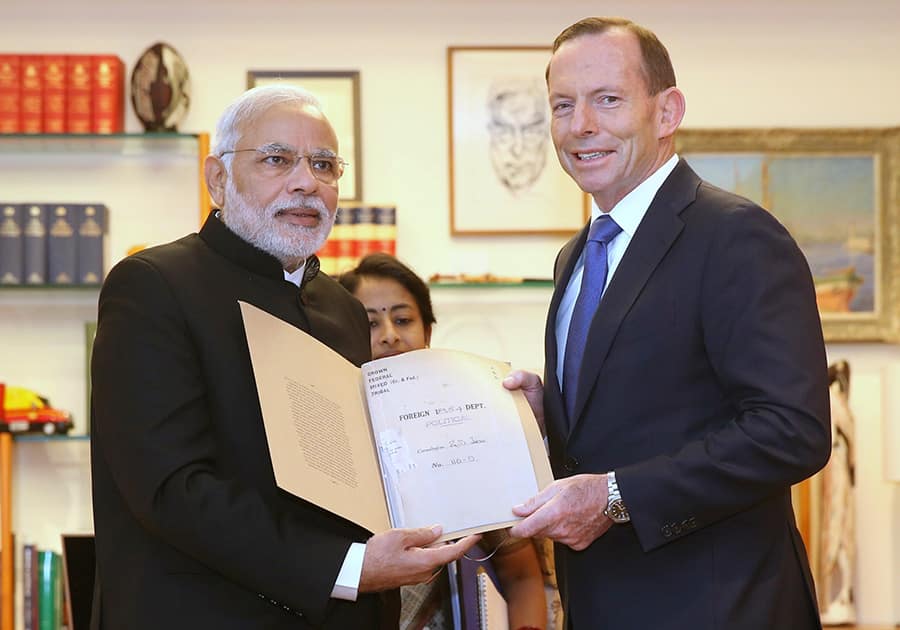 PM Narendra Modi, presents a historical document from the 19th century to Australian Prime Minister Tony Abbott in Parliament House in Canberra. Modi has called for a closer strategic partnership between India and Australia as well as a closer trading relationship.