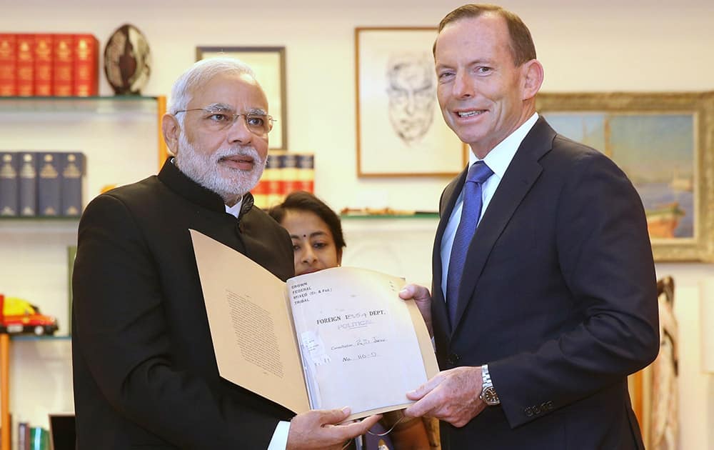 PM Narendra Modi, presents a historical document from the 19th century to Australian Prime Minister Tony Abbott in Parliament House in Canberra.