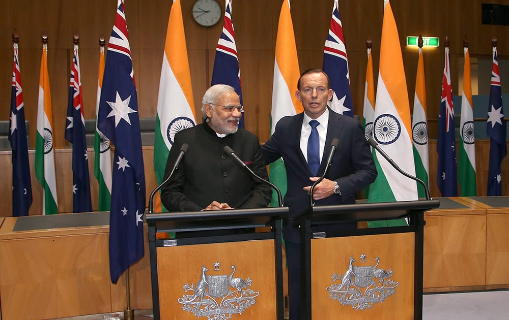 Australia's Prime Minister Tony Abbott, puts his arm around PM Narendra Modi during a joint press conference at Parliament House in Canberra.