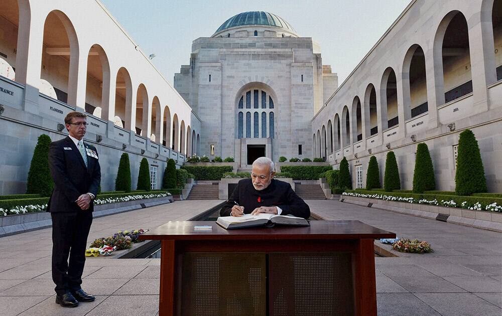 Prime Minister Narendra Modi signs visitors book during a visit to Australian War Memorial.