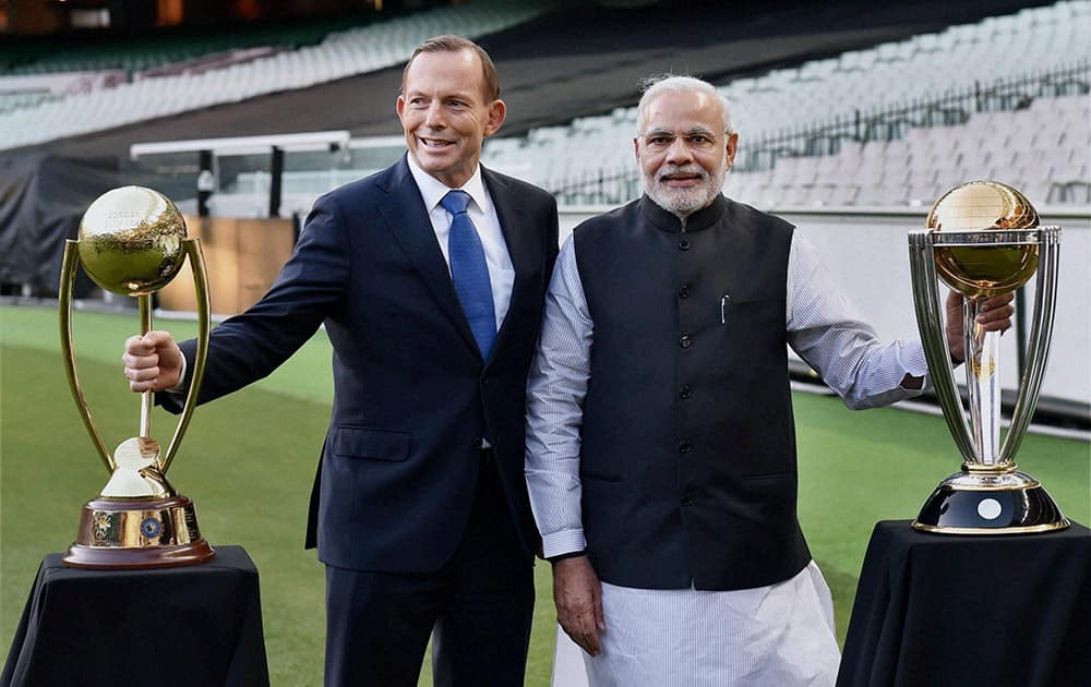 Prime Minister Narendra Modi and his Australian counterpart Tony Abbott pose for photographs with World Cup trophies during a function at Melbourne Cricket Ground in Melbourne.