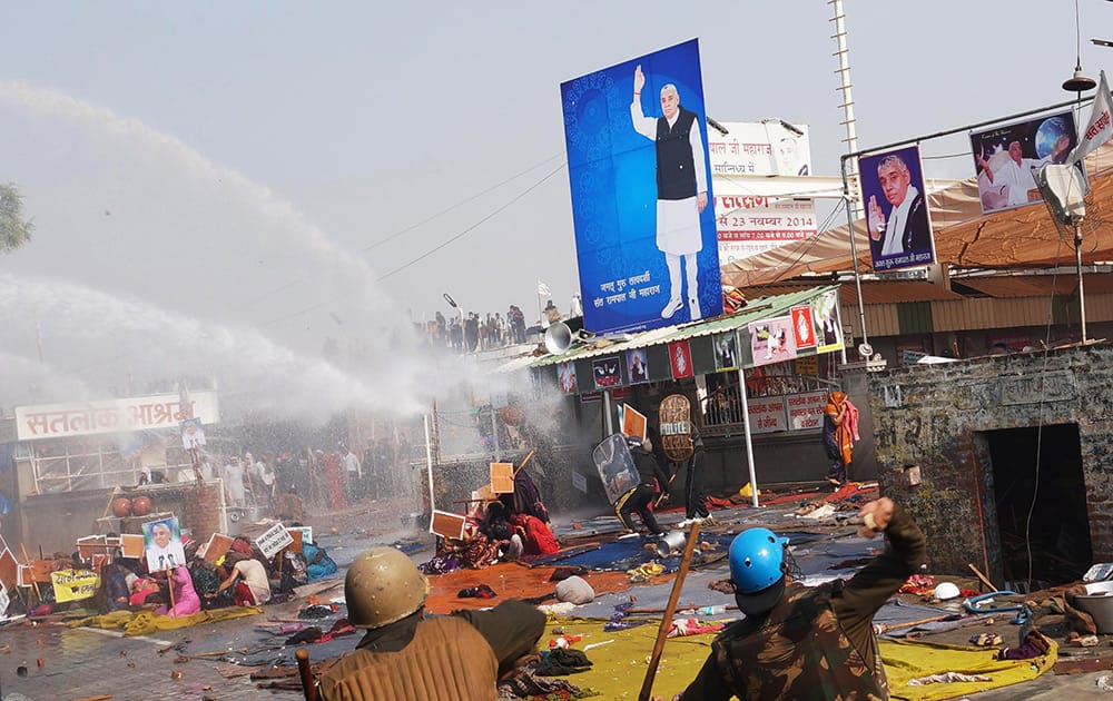 Police use batons and water cannon to disperse supporters, as they storm the ashram of controversial guru Sant Rampal, at Hisar in Haryana.