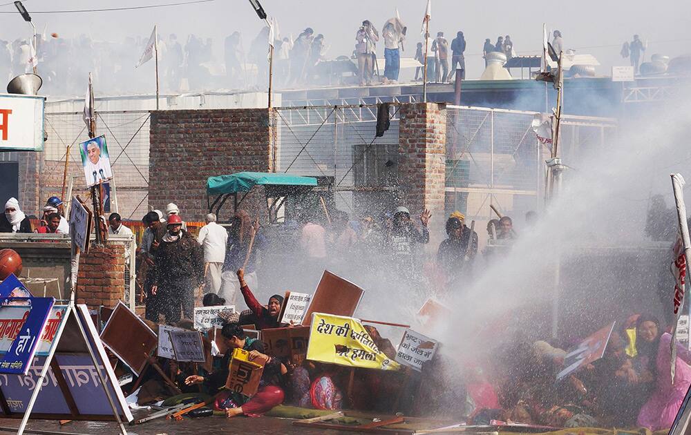 Supporters try to resist police water cannon as police storm the ashram of controversial guru Sant Rampal, in search of him at Hisar in Haryana.